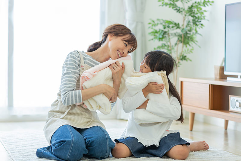 洗濯をたたむ親子